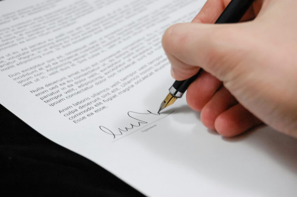 document-agreement-documents-sign-48148-48148 Close-up of a hand signing a legal document with a fountain pen, symbolizing signature and agreement.